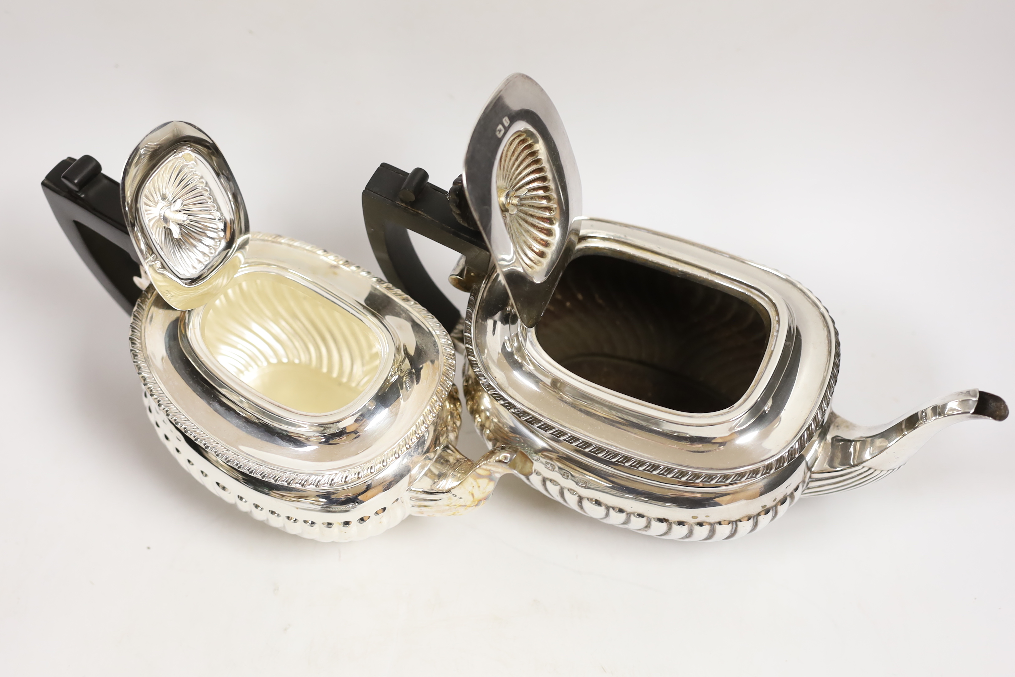 A late Victorian demi fluted silver three piece tea set, William M. Hayes, Birmingham, 1897, together with another demi fluted silver teapot and sugar bowl, same maker, Birmingham, 1898, gross weight 52.6oz.